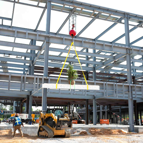 A construction crane lifting a steel beam.