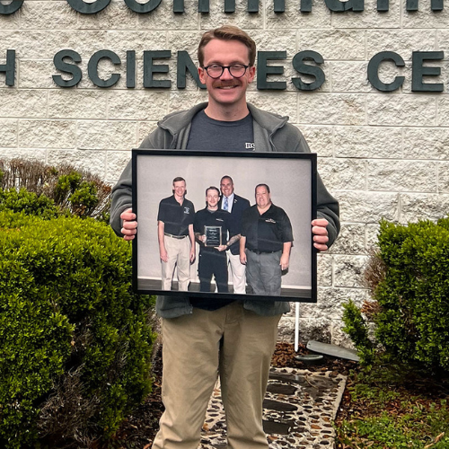 A man holding a framed photo.